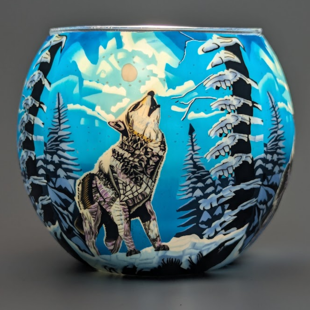 Decorative globe with a wolf howling at the moon design on a snowy landscape.