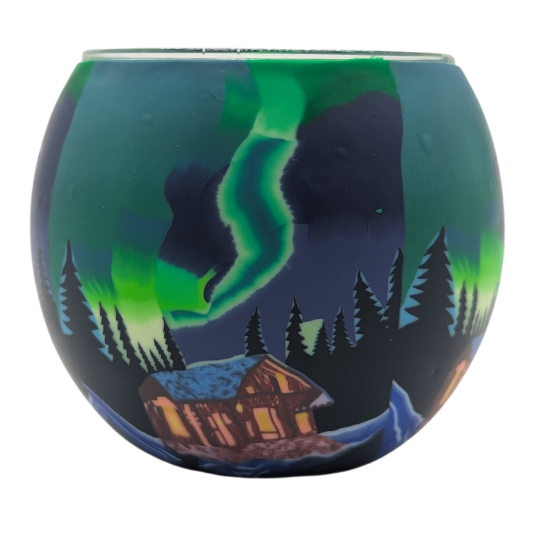 Glass light globe with a design of the Northern Lights over a cabin in the woods.