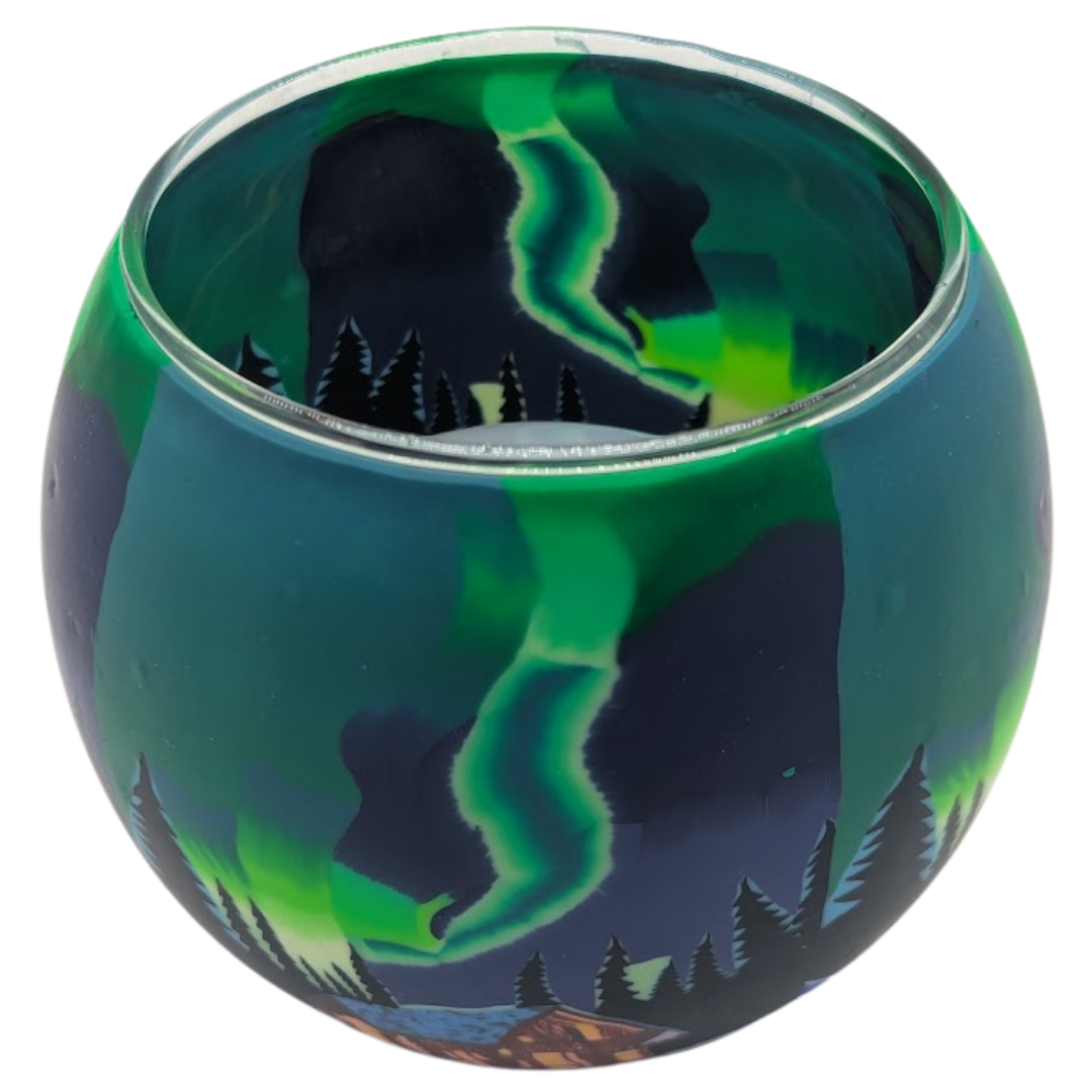 Glass light globe with a design of the Northern Lights over a cabin in the woods.